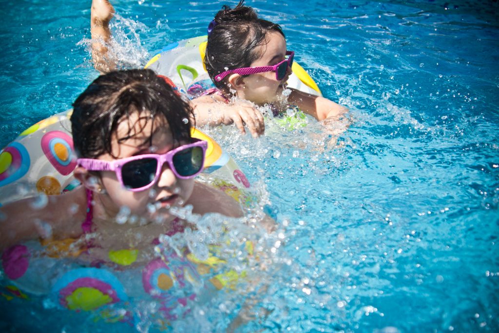 deux jeunes filles de moins de 8 ans qui nagent dans l'eau d'une piscine pendant les vacances